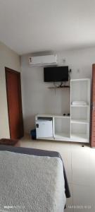 a bedroom with a bed and a tv on the wall at Pousada Santo Rio in Piranhas