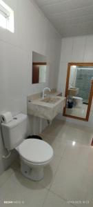 a white bathroom with a toilet and a sink at Pousada Santo Rio in Piranhas