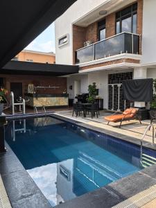 Tnmax Luxury Home Abuja في Garki: منزل به حوض سباحة أمام المنزل