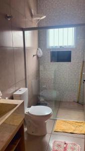 a bathroom with a toilet and a glass shower at Chácara Recanto das Aves in Pilar do Sul