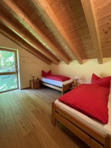 a bedroom with two beds with red pillows at Ferienhaus Baumberger in Oberammergau