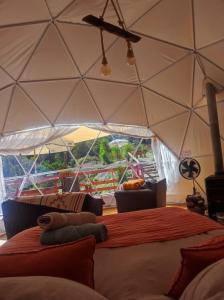 una habitación con una cama en una tienda de campaña en Domo con Hot Tub Piscina Sauna Olmue, en Olmué
