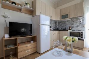 a kitchen with a white refrigerator and a tv at BALLET MAISON in the heart of the city in Alexandroupoli