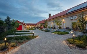 a courtyard of a building with a pathway and lights at Magister Apartmanház in Cserépfalu