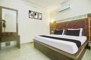 a bedroom with a large bed and a mirror at Hotel O Subash Inn in Jalandhar