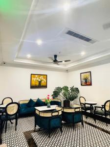 een woonkamer met een bank en tafels en stoelen bij The Room Hotel - Starbucks in Phu Quoc