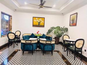 a living room with blue chairs and a table at The Room Hotel - Starbucks in Phú Quốc