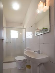 a white bathroom with a sink and a toilet at Porto Paraty Residencial in Paraty +90 photos