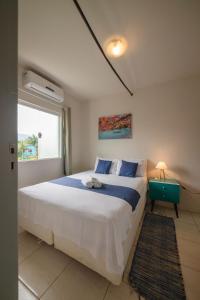 a bedroom with a large bed and a window at Porto Paraty Residencial in Paraty