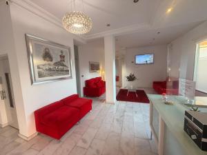 a living room with red chairs and a red couch at Hotel Fernando IV in Martos