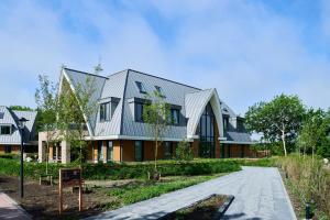 a house with a metal roof on a road at Droomsuites Texel 4 personen by Droomvilla in Den Burg