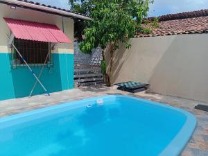 a blue swimming pool in front of a house at Refúgio familiar in Belém