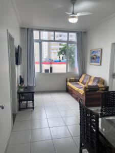 a living room with a couch and a window at Apartamento 2 suítes Pitangueiras Guarujá in Guarujá