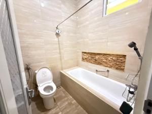 a bathroom with a white tub and a toilet at Ivo Homestay Jogja in Gondowulung +17 photos