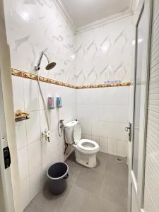 a bathroom with a toilet and a shower at Ivo Homestay Jogja in Gondowulung