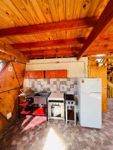 a kitchen with a stove and a refrigerator at Domo Del Rio in Los Reartes