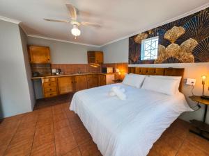 a bedroom with a white bed with a stuffed animal on it at Tau Golden Mane in Johannesburg