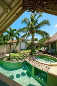 un cortile con piscina e palme di The White Key Luxury Villas a Gili Trawangan