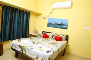 a bedroom with a bed with two red pillows at DilsBreak HomeStay in Kanyakumari