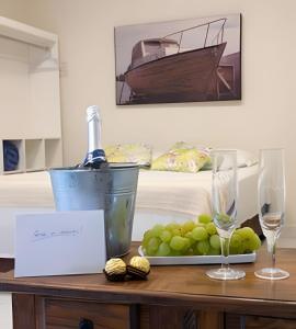 a table with a plate of grapes and a bottle of wine at Flats Premium Jabaquara in Paraty