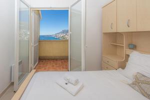 - une chambre avec un lit blanc et une porte en verre dans l'établissement Maison unique - Incroyable vue mer - Piscine - EO, à Roquebrune-Cap-Martin 50 autres photos