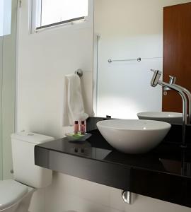 a bathroom with a black counter with a sink and a toilet at Flats Premium Jabaquara in Paraty +71 photos