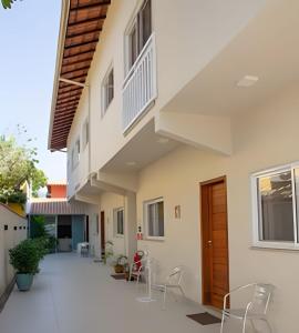 a courtyard of a house with chairs and a staircase at Flats Premium Jabaquara in Paraty
