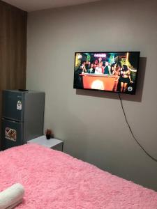 a flat screen tv hanging on a wall in a bedroom at Akb Home Nyayo Studio in Nairobi