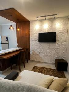 东普里马韦拉Lar Aconchegante 2min do centro的卧室的墙上有一台电视和一张书桌