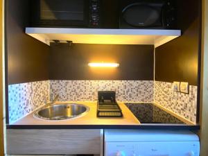 a small kitchen with a sink and a microwave at Appartement cosy 2 pièces pour 6 personnes à Arc 1600, proche des pistes - FR-1-411-337 in Bourg-Saint-Maurice +9 photos