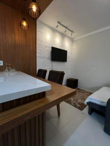 a kitchen and living room with a table and a tv at Lar Aconchegante 2min do centro in Primavera do Leste