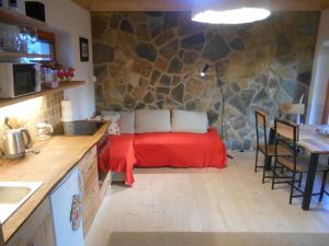 a kitchen with a red bed in a stone wall at Na Váze in Jindřichŭv Hradec