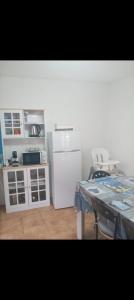 Una cocina con un refrigerador blanco y una mesa. en Lucky House, en Muravera 7 fotos más