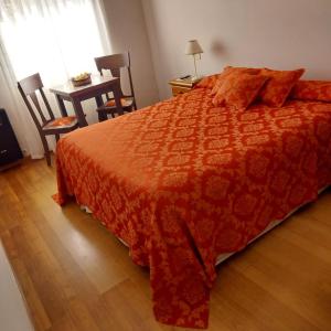 Un dormitorio con una cama y una mesa y una ventana. en Hotel El Descanso, en Junín