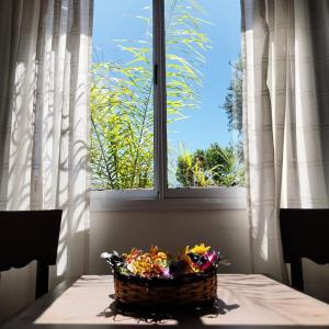 a basket of flowers sitting on a table in front of a window at Hotel El Descanso in Junín