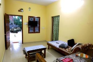 a living room with a couch and a table at DilsBreak HomeStay in Kanyakumari