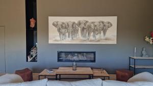ラ・ガルド・フレネにあるChambres d'hôtes Le Pontillaouの象の群れの絵が飾られたリビングルーム