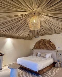 a bedroom with a large bed with a ceiling at Agafay Luxury camp in Marrakech