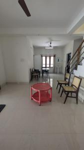 a living room with a red table and chairs at Sinai Homestay in Trivandrum