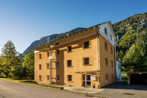 a large yellow building on the side of a road at homy Alpenlodge in Innerbraz