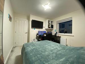 una camera da letto con un letto e una scrivania con un computer di Moore Place a Houghton Regis