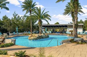 a swimming pool with palm trees and a resort at Book Me Baby! Take It Easy On 30A in Blue Gulf Beach