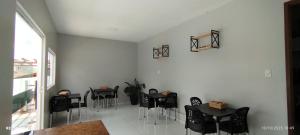 a dining room with black tables and chairs at Pousada Santo Rio in Olho D’Água do Casado