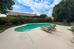a couple of chairs sitting next to a swimming pool at Casa de la Quinta in Bermuda Dunes