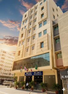 a large building with flags in front of it at Town Plaza Hotel Apartments Ras Al Khaimah in Ras al Khaimah