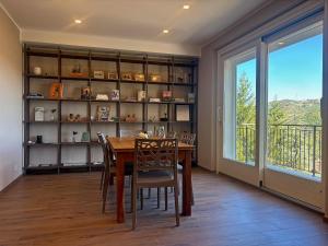 Un comedor con mesa y sillas y una ventana. en Borgo al Bosco, en Amandola