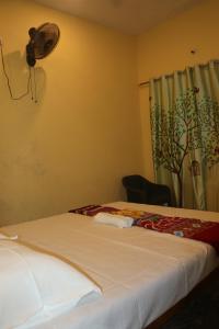 ゴカルナにあるKudle Heavenのベッドルーム1室(ベッド1台、壁にファン付)