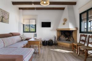 ein Wohnzimmer mit Couch und Kamin in der Unterkunft Casa rural El Moral in Prado del Rey