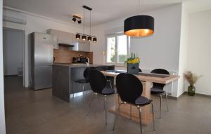 イカにあるApartman Summer Breeze by Villas Guideのテーブルと椅子と冷蔵庫のあるキッチン