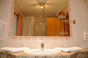 a bathroom with a sink and a mirror at Hotel Neuwirt in Brandenberg +52 photos